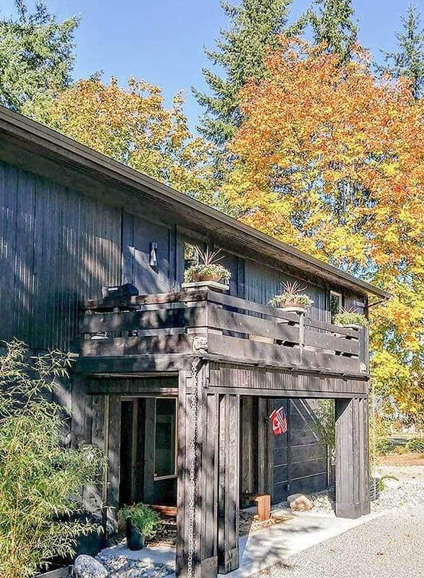 A closer look at the entry porch under the sun deck supported by rustic columns.