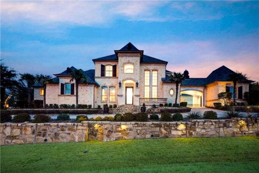 Home's facade with arched front porch, an enticing veranda, and a porte-cochere connecting the garage.