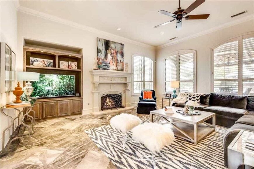 The family room offers a large TV and a fireplace enclosed in an ornate wrought iron screen.