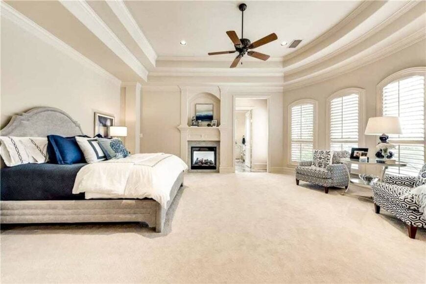 The primary suite boasts a fireplace and a sitting area by the bay window facing the comfy bed.