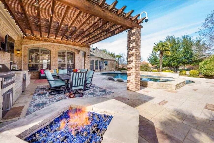 The outdoor living space filled with a fire pit, a lanai, and a tranquil swimming pool with tiled paving.