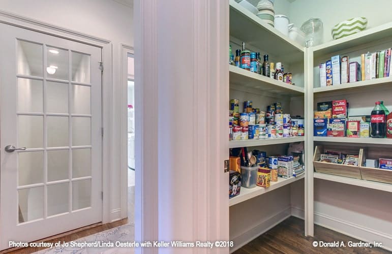The walk-in pantry offers lots of storage filled with drinks and foods.