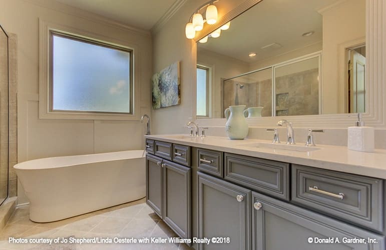 The primary bathroom is equipped with a freestanding tub and a dual sink vanity lit by warm sconces.