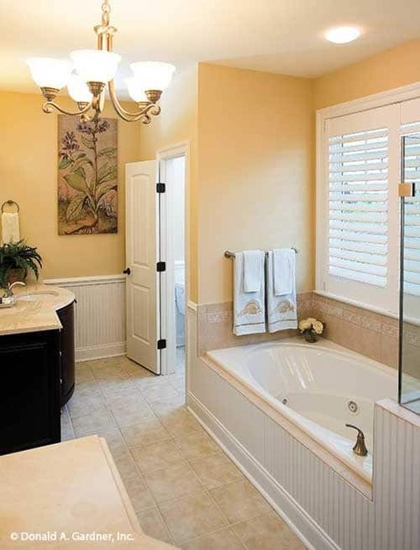 The primary bathroom offers two sink vanities, a separate shower, and a drop-in tub under the white louvered window.