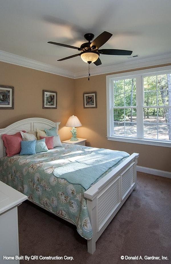 This bedroom features white furnishings that create a stunning contrast to the brown walls and carpet flooring.