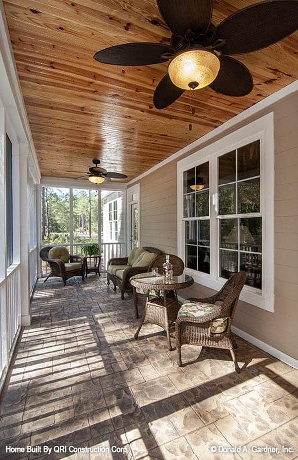 Wicker seats and warm ceiling fans complete the screened porch.