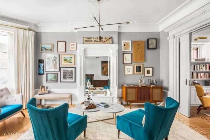 The living room with wooden furniture and a stunning pendant lights a cozy sofa with a table on the carpet flooring.