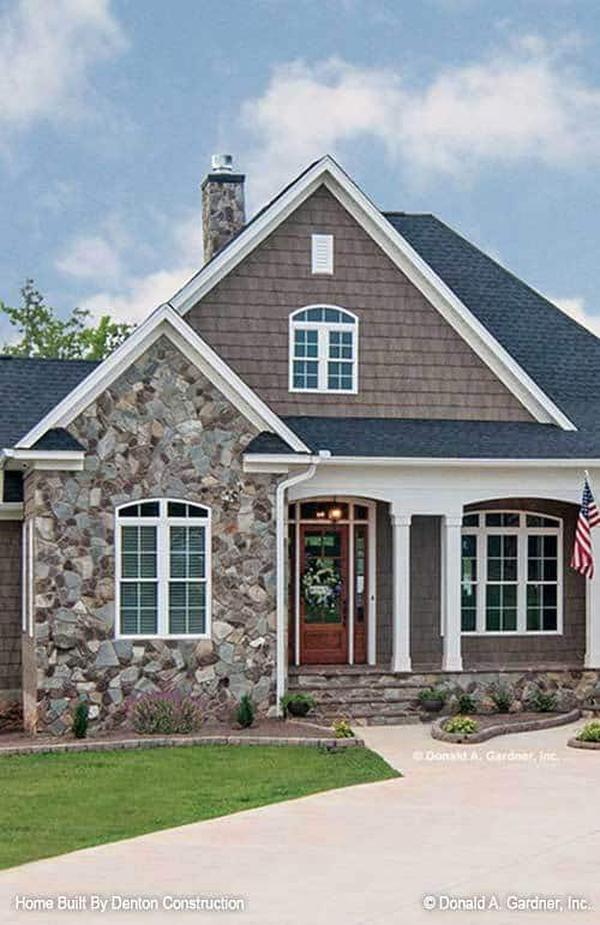Home's rear view shows the angled screened porch, covered patio and lower porch framed with stone columns.