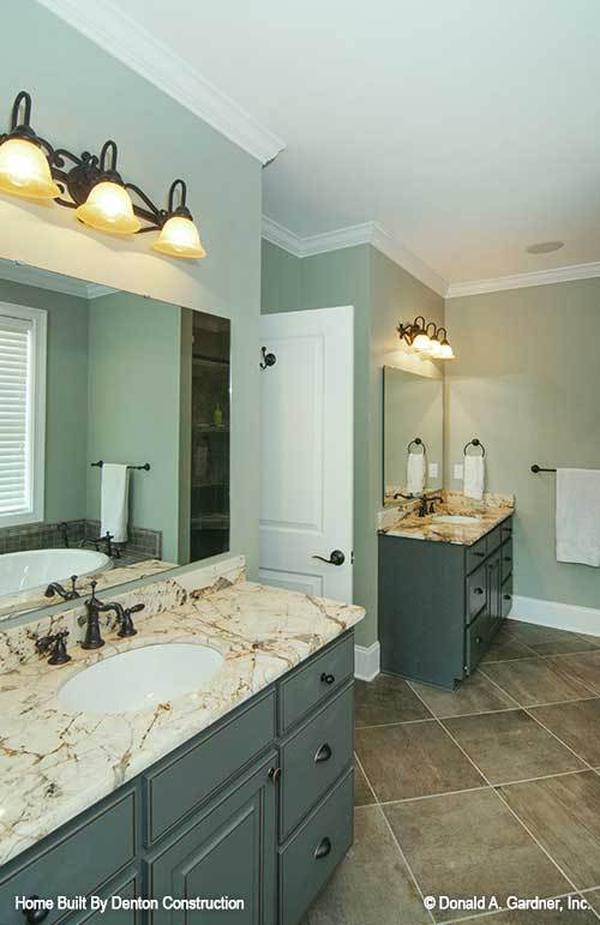 The primary bathroom features his and her sink vanities with marble countertops and frameless mirrors.