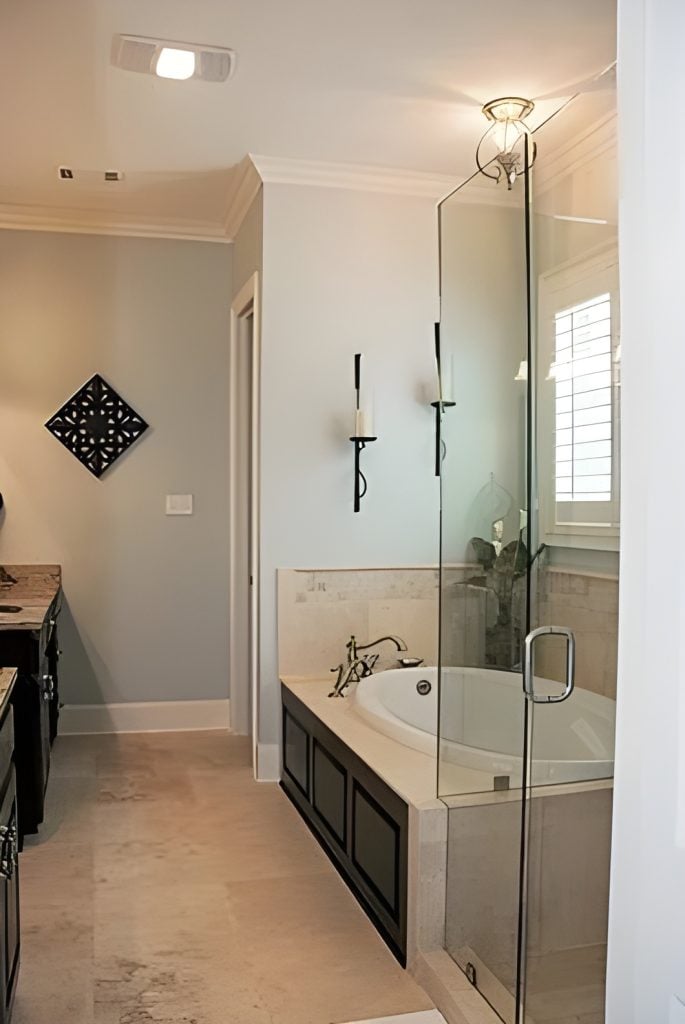Primary bathroom with dual sink vanities, a corner tub, and a walk-in shower enclosed in frameless glass.