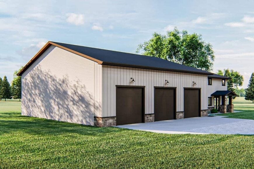 The home's angled view shows the three-car garage with dark brown doors illuminated by dome sconces.