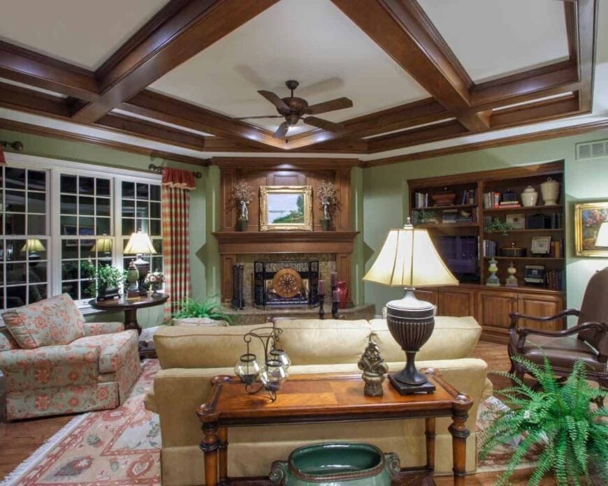 The hearth room has a beautiful coffered ceiling and a cozy fireplace topped with a gilded artwork and flower vases.