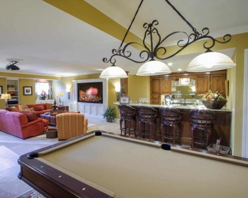 Recreation room complete with a media area, a wet bar, and a billiard table under the glass dome pendants.