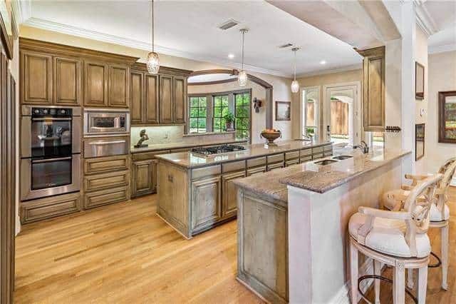 The kitchen offers plenty of counter space and wooden cabinets that blend in with the hardwood flooring.