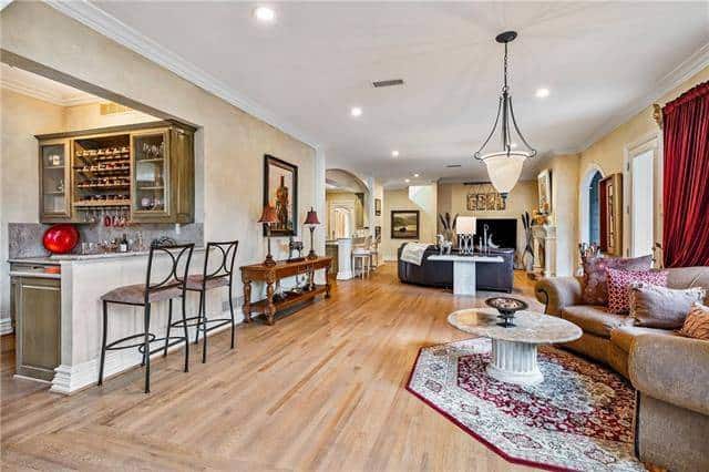 Family room with a curved sofa and a marble coffee table facing the bar.