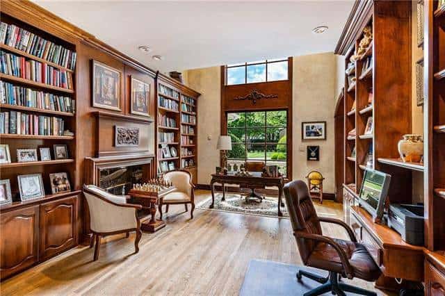 Spacious study with lots of built-ins and desks, and a massive window that invites natural light in.