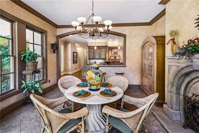 Breakfast nook across the kitchen with tiled flooring and beige walls lined with brown mouldings.