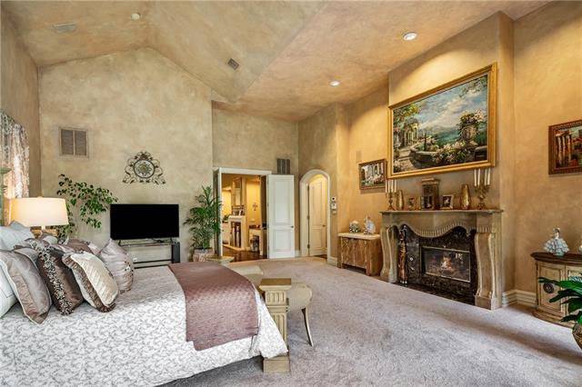 The primary bedroom includes a TV and a romantic fireplace fixed under the beautiful landscape painting.