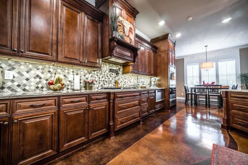 A close-up look at the rich wooden cabinetry accentuated with mosaic-tiled backsplash.