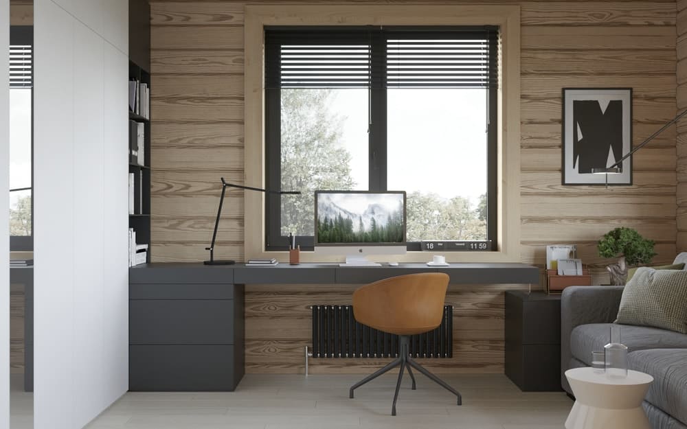 This is a simple office with a modern black desk with built-in drawers and shelves on the side that contrast the white wall beside it.