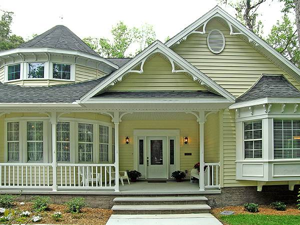 Home entry with a concrete stoop and a white front door flanked by warm outdoor sconces.