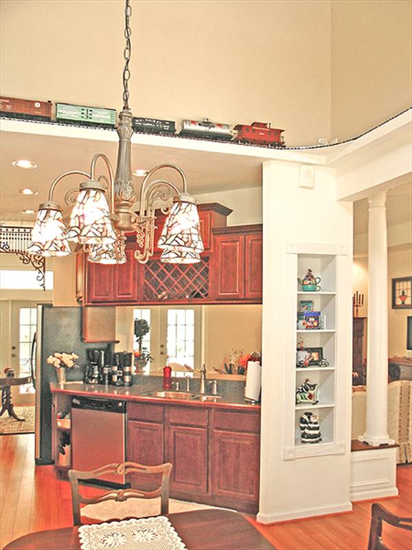Another view of the kitchen showing the breakfast area with a wooden dining set and an ornate chandelier.