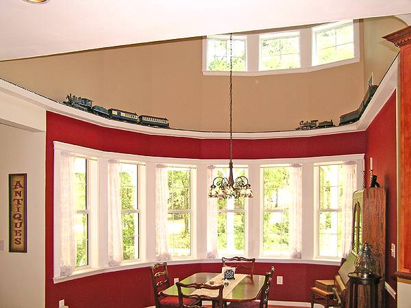 The dining room offers wooden furnishings and plenty of white framed windows fixed against the red walls.