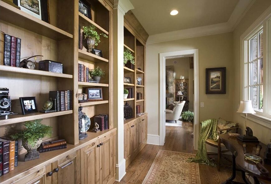 The study offers wooden furniture and a large built-in bookcase that blends in with the hardwood flooring.