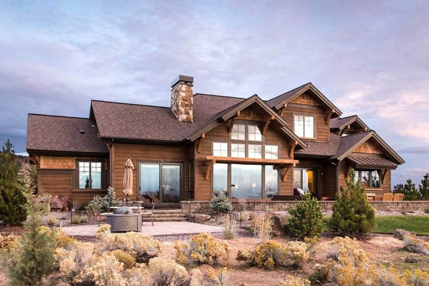 A farther view shows the dark wood loungers and a fire pit seating on the open patio.