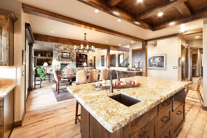 The kitchen island has dark wood pull-outs, a granite countertop, and an undermount sink paired with a gooseneck faucet.