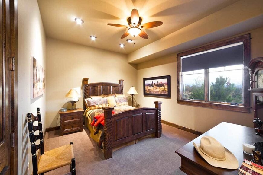 This bedroom has carpet flooring and beige walls adorned with various artworks.