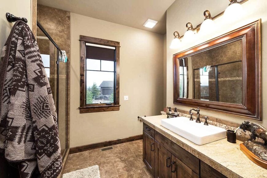 The bathroom offers a walk-in shower and a wooden vanity with vessel sink and wrought iron fixtures.