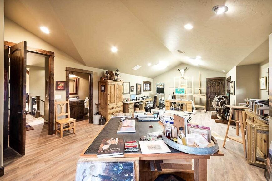 A large recreation room with vaulted ceiling and wooden furnishings that match the hardwood flooring.