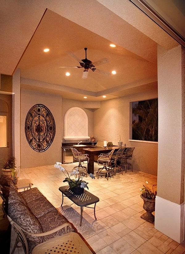 Barbecue area with summer kitchen, an eating bar. and cushioned seats paired with a metal coffee table.