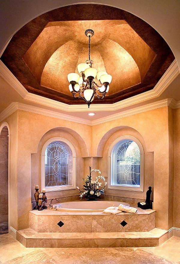 An opulent primary tub situated under the stunning dome ceiling mounted with a warm chandelier.