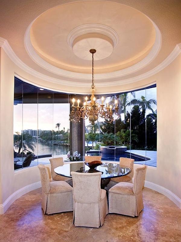 A closer look at the breakfast nook shows the panoramic window overlooking the sparkling pool.
