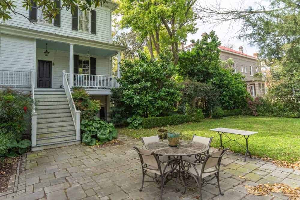 This is the lovely patio fitted with an outdoor dining area to better enjoy the surrounding landscape. This area is marked with a concrete flooring beside the grass lawn.
