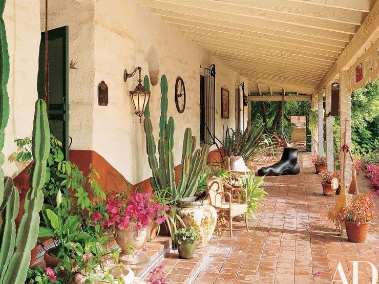 This is the patio of the house filled with decorative potted plants and sculptures that bring charm to the area. This has terracotta flooring tiles that transitions to the garden beside it.