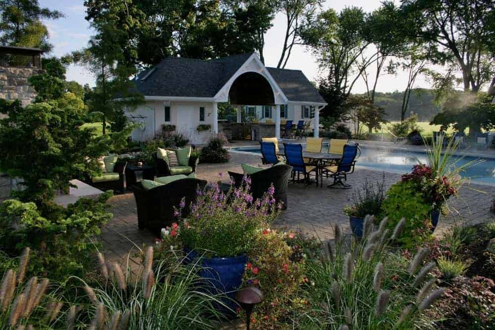 This is the gorgeous backyard patio that connects with the poolside area via terracotta brick walkways that transition to the gorgeous surrounding garden of lush landscaping.