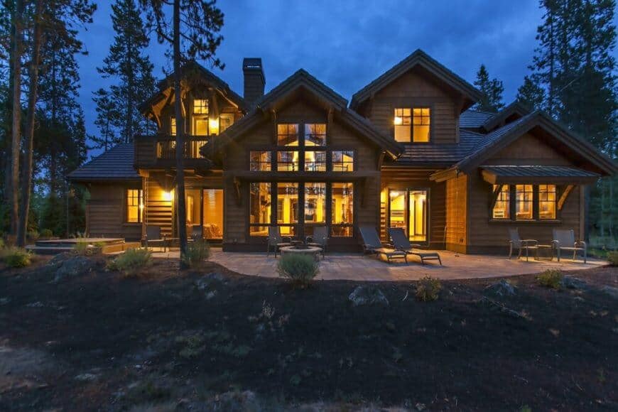 The stone patio at the rear of the home, with a fire pit located in front of the large windows in the great room.