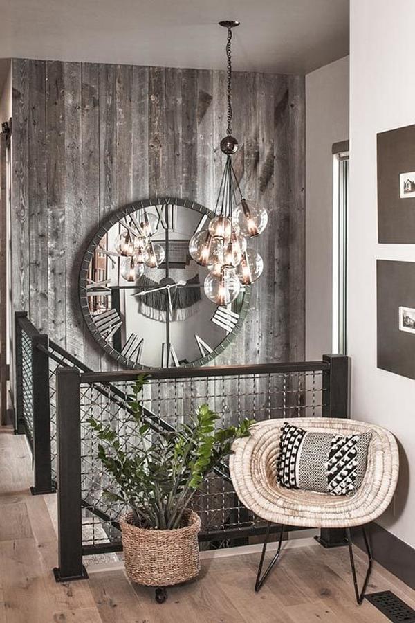 The foyer has a fresh potted plant and a round chair accented with a patterned pillow.