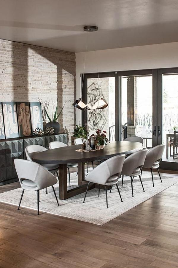 The dining room has an 8-seater dining set and a sleek buffet bar topped with round decors and multi-panel artwork.