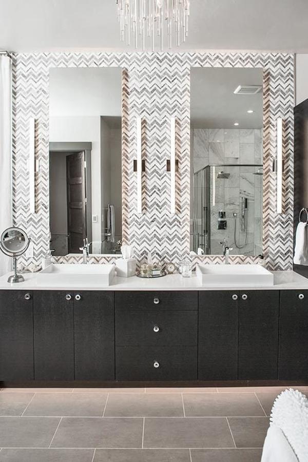 This bathroom offers a dark wood vanity with vessel sinks under the rectangular frameless mirrors.