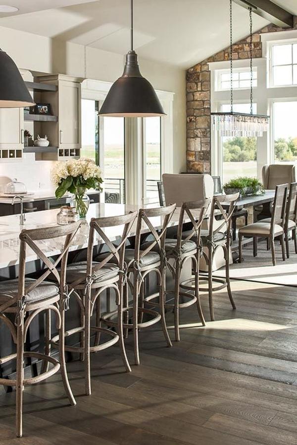 Kitchen island across the dining area lined with cushioned wooden counter chairs.