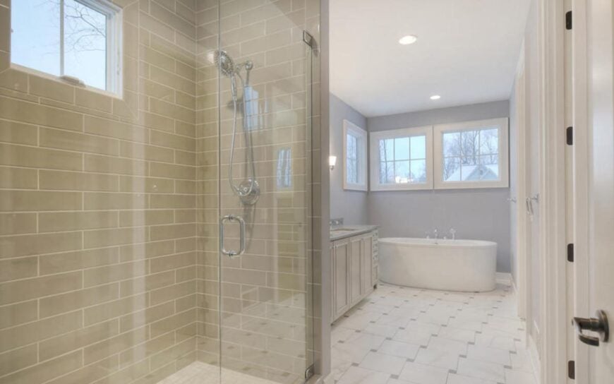 The primary bathroom is equipped with a separate shower and a freestanding tub situated against the light blue walls.