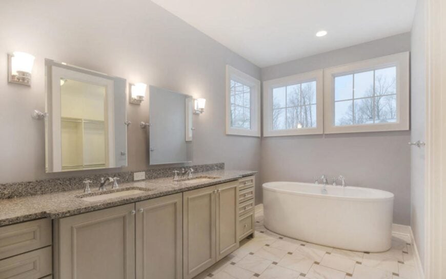 The deep soaking tub is complemented with a dual sink vanity that's topped with an elegant granite countertop.