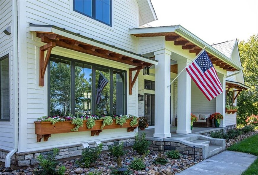 Decorative exterior columns adorned with a flag support the front porch.