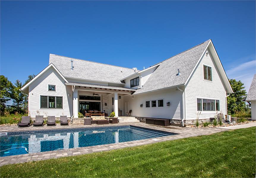 The angled view shows the sparkling pool complemented with wicker seats and dark loungers.