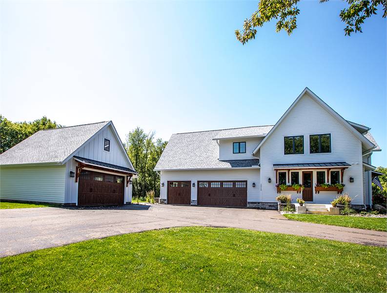 A farther view of the house showing the 3-car garage along with a side entry.