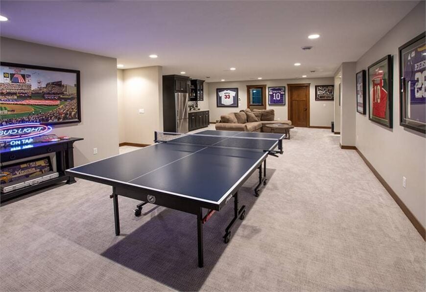 A closer look at the pingpong table surrounded with framed jerseys.